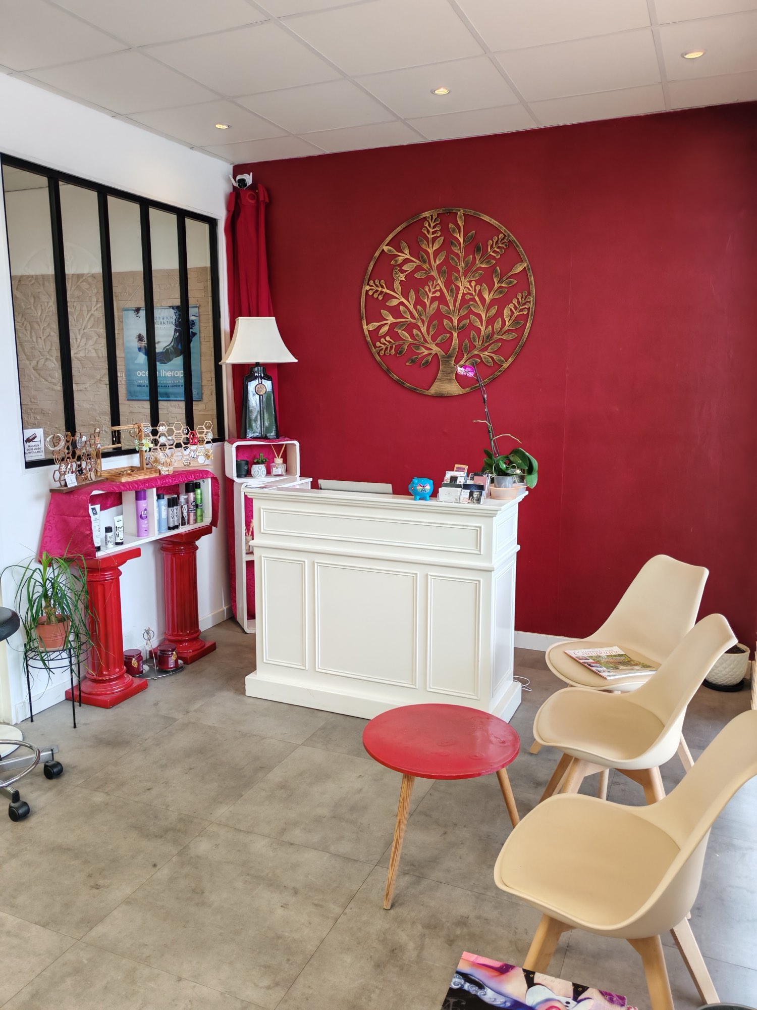 Espace accueil, comptoir, arbre de vie doré, lampe ambrée et chaises Eames